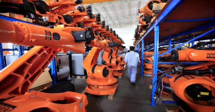 FILE PHOTO: A worker walks past second-hand robots in a factory in Shanghai