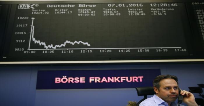 Trader speaks on phone in front of DAX board at Frankfurt's stock exchange