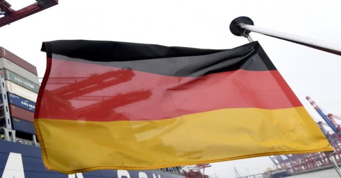 A German flag flutters next to the ships at the loading terminal in the port of Hamburg