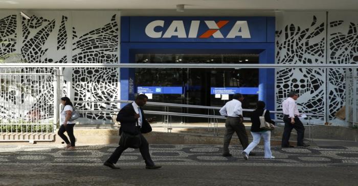 People walk past a Caixa Economica Federal bank in downtown Rio de Janeiro
