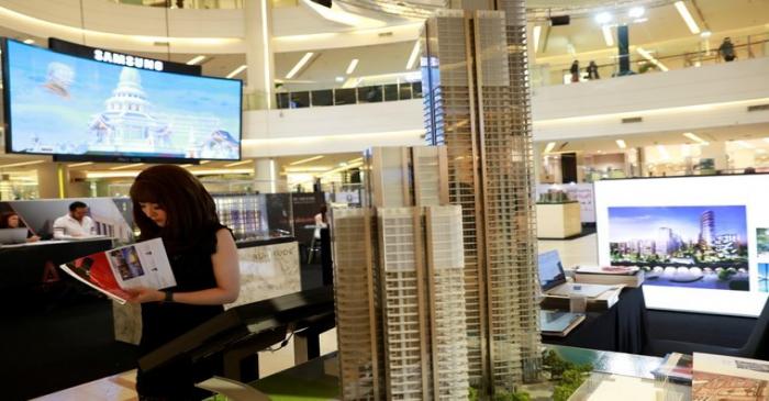 Promotion staff sell their new condo project in a shopping center in Bangkok
