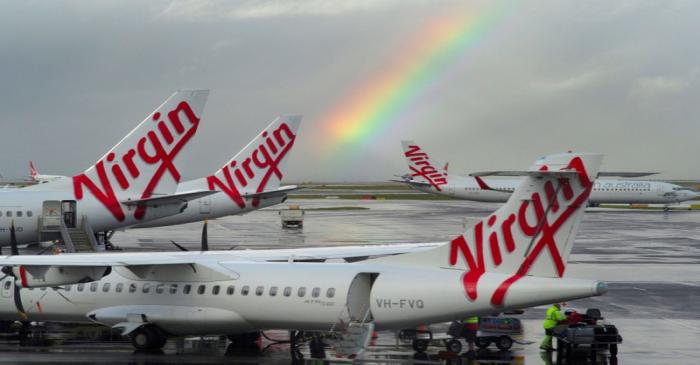 FILE PHOTO: A rainbow from a passing rain shower sits over Virgin Australia aircraft at Sydney