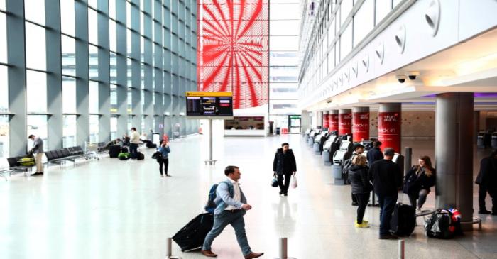 Passengers walk through Heathrow Terminal Three in London