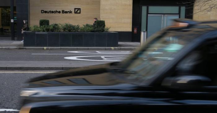 FILE PHOTO: A London taxi is driven past a Deutsche Bank building in the City of London
