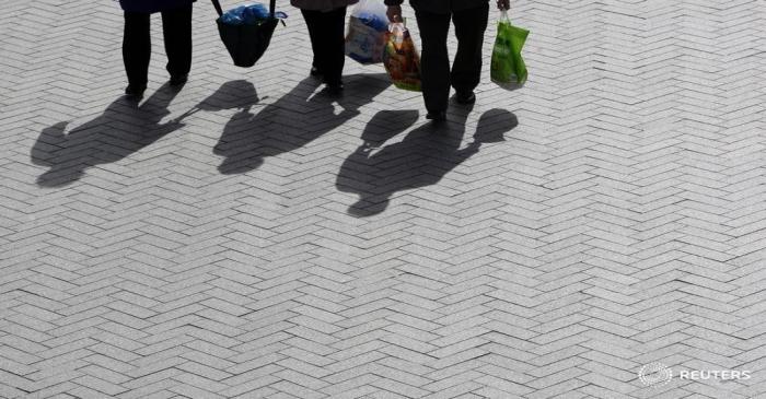FILE PHOTO: The shadows of shoppers are cast onto the ground in Birmingham