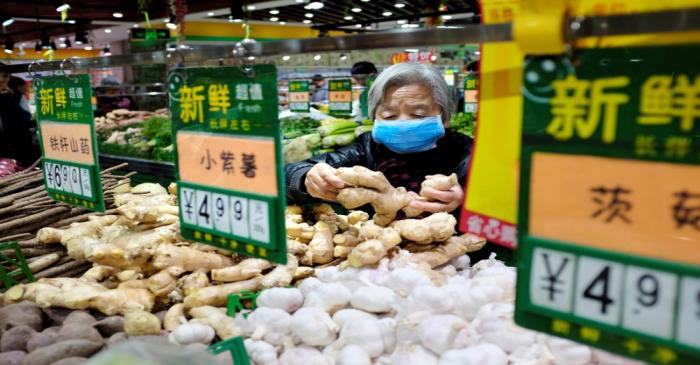 A resident selects ginger at a supermarket in Beijing