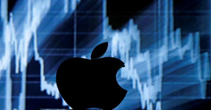 FILE PHOTO: A 3D printed Apple  logo is seen in front of a displayed stock graph in this