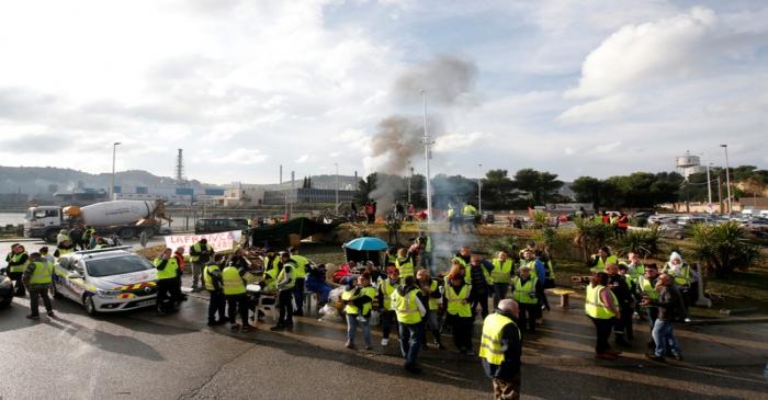 Demonstrators wearing yellow vests, a symbol of a French drivers' protest against higher fuel