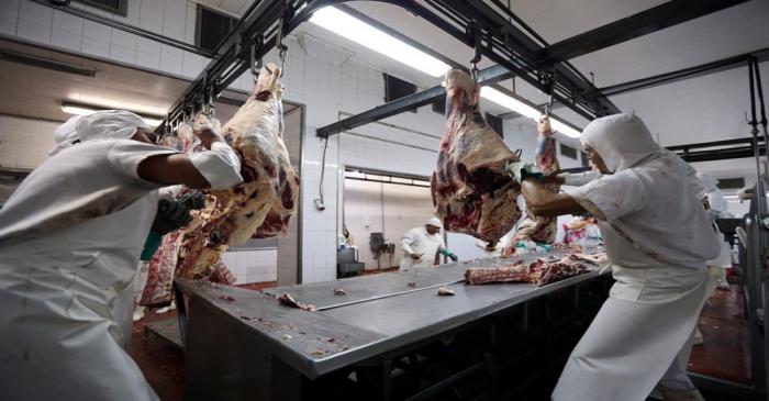 Workers handle beef carcasses at the Ecocarne Meat Plant slaughterhouse in San Fernando