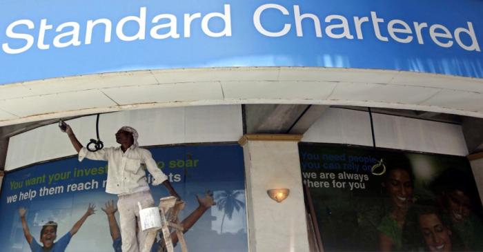 A labourer paints the wall of a Standard Chartered bank in Mumbai