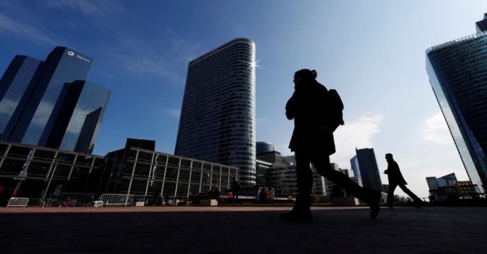 People walk on the esplanade of La Defense in the financial and business district of La