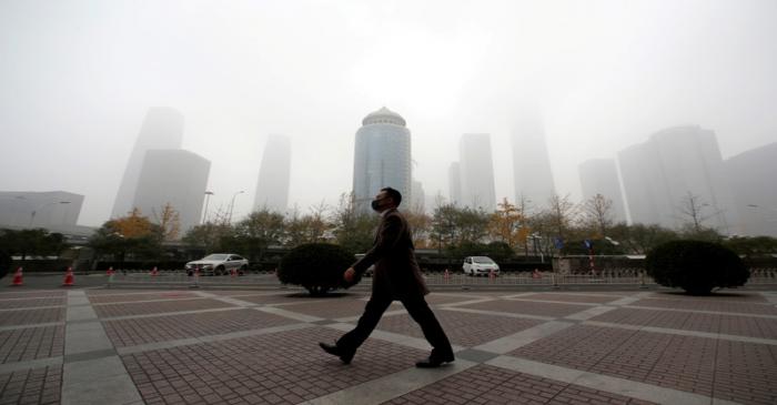FILE PHOTO - Man wearing a mask walks in the central business district on a polluted day after