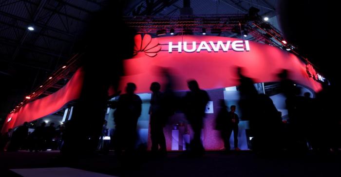 FILE PHOTO: Visitors walk past Huawei's booth during Mobile World Congress in Barcelona