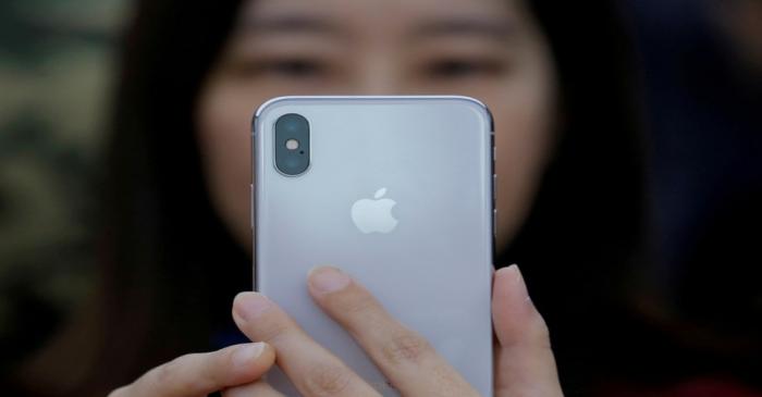 FILE PHOTO - An attendee uses a new iPhone X during a presentation for the media in Beijing