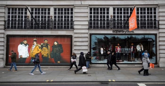 bShoppers walk past a window display at a Superdry store on Regents Street in London