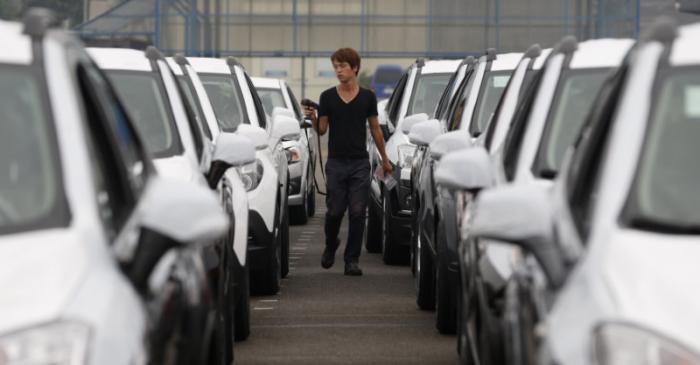 A worker checks cars made by GM Korea in a yard of GM Korea's Bupyeong plant in Incheon