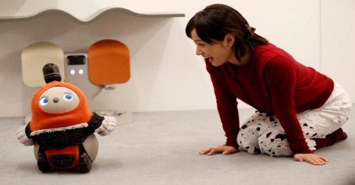 A woman calls up GROOVE X's new home robot LOVOT at its demonstration during the launching