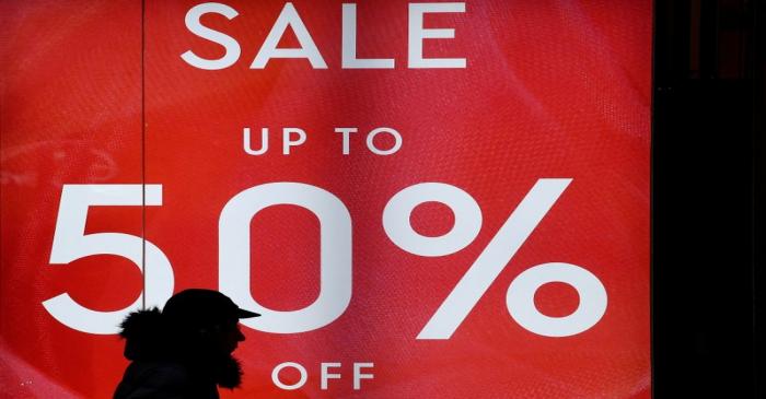 FILE PHOTO: A person walks past a sale sign on Oxford Street in London
