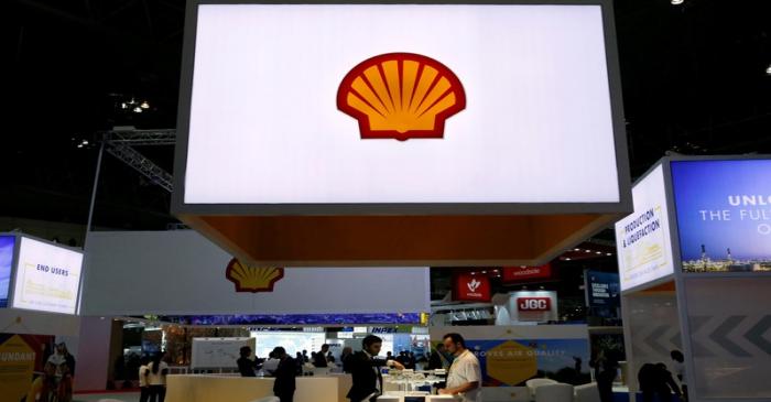 Staff members work at the booth of Royal Dutch Shell at Gastech, the world's biggest expo for