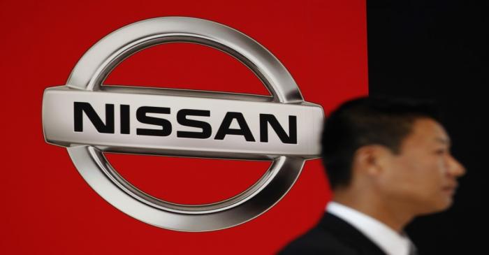 FILE PHOTO:  A staff stands in front of a logo of Nissan Motor Co at the company showroom in