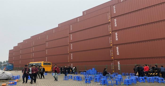 Workers are seen outside at a Maersk container factory in Dongguan