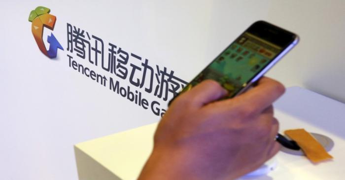 FILE PHOTO: Visitor plays a game on a smartphone at Tencent's exhibition booth at the Global