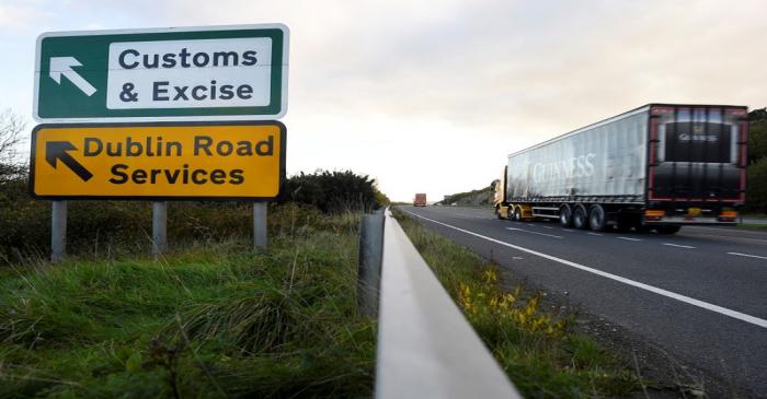 A Guinness truck passes a sign for Customs and Excise on a road near the border with Ireland
