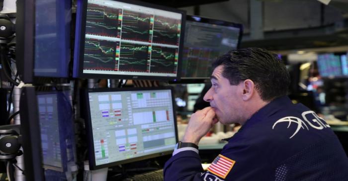 FILE PHOTO: A trader watches price monitors on the floor at the New York Stock Exchange (NYSE)