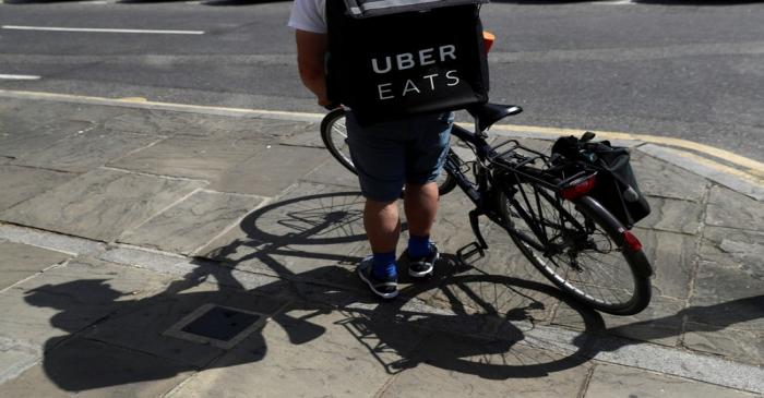 FILE PHOTO: A cyclist prepares to delivery an Uber Eats food order in London