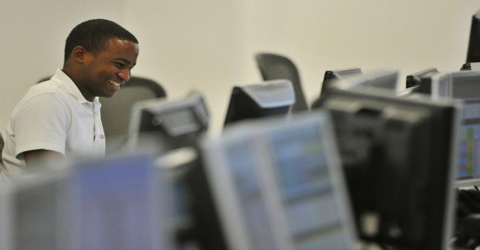 A dealer smiles on the trading floor of IG Index in the City of London