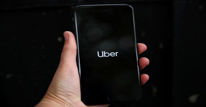 FILE PHOTO: Uber's logo is displayed on a mobile phone in London
