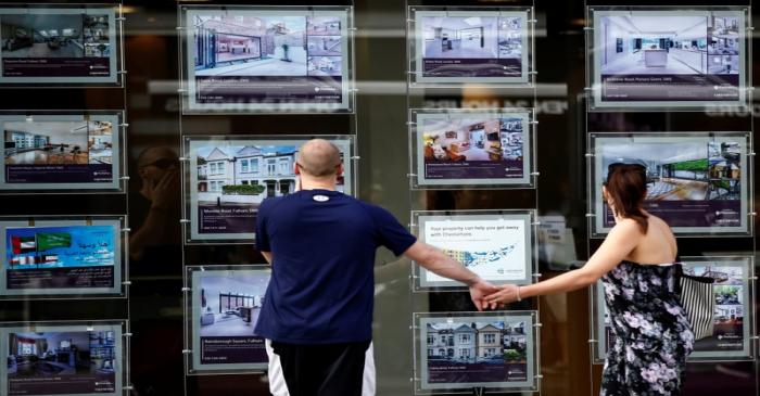 FILE PHOTO: A couple view properties for sale in an estate agents window in London