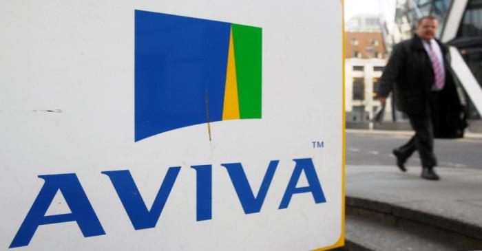 FILE PHOTO: A man walks past an AVIVA logo outside the company's head office in the city of