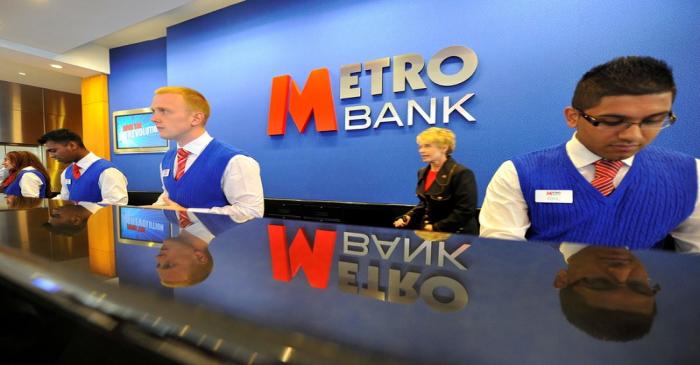 FILE PHOTO: Staff serve customers at the first branch of  Metro Bank in Holborn in central
