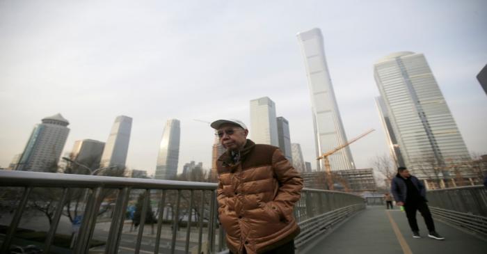 FILE PHOTO: People walk through an overpass near Beijing's central business area