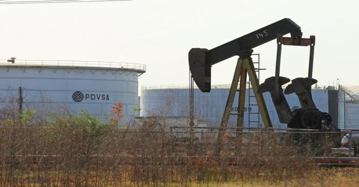 FILE PHOTO: An oil pumpjack and a tank with the corporate logo of state oil company PDVSA are