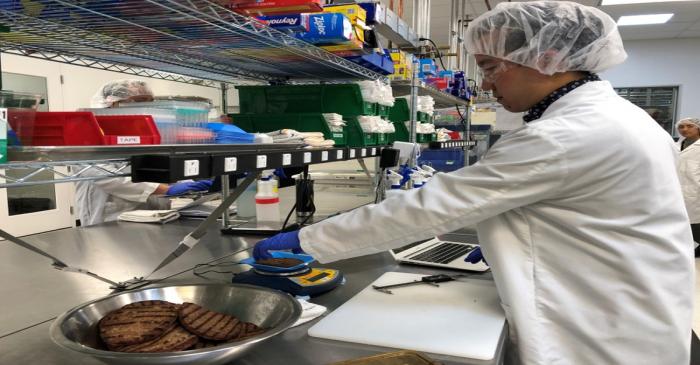 Impossible Foods product development associate scientist Kyle Okada measures plant-based