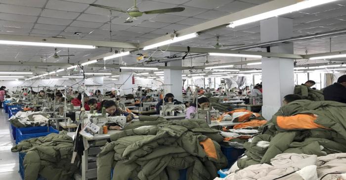 FILE PHOTO: Workers make Orolay jackets at the company's factory complex in Jiaxing, Zhejiang