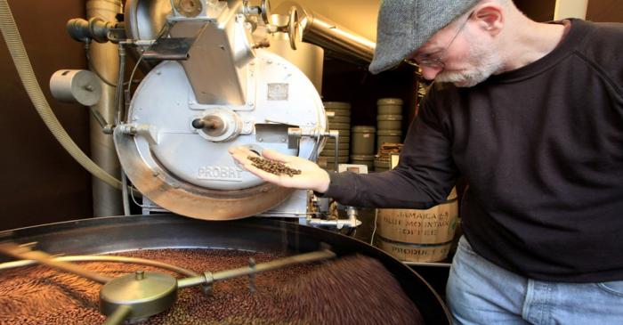 FILE PHOTO: An employee checks freshly roasted coffee beans at H. Schwarzenbach coffee roastery