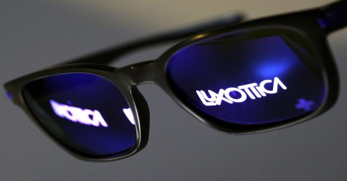 FILE PHOTO: FILE PHOTO - The Luxottica name is reflected in a pair of sunglasses  in this photo