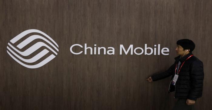 A man walks past the China Mobile logo at the Mobile World Congress in Barcelona