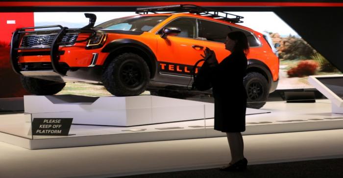 FILE PHOTO: A woman photographs cars on display at the 2019 New York International Auto Show in