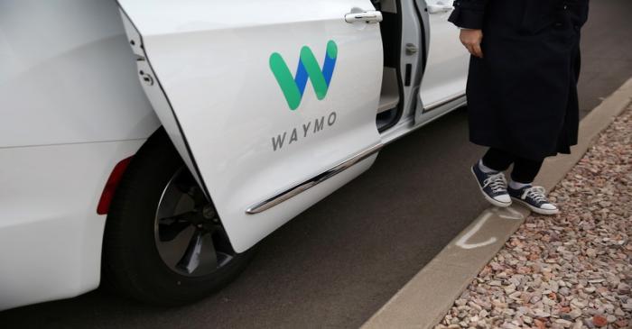 Reuters reporter Alexandria Sage steps out of a Waymo self-driving vehicle during a