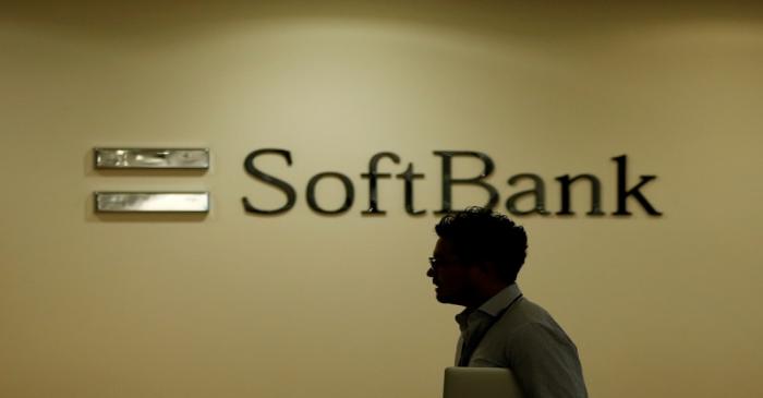 Man walks past the logo of SoftBank Group Corp at the company's headquarters in Tokyo