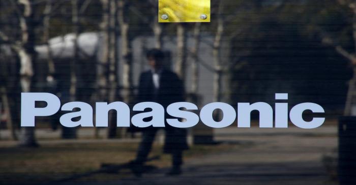 A man is reflected on Panasonic Corp's logo at Panasonic Center in Tokyo