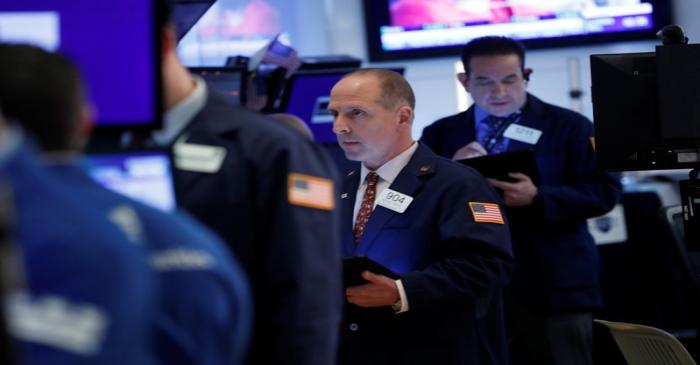 Traders work on the floor at the NYSE in New York