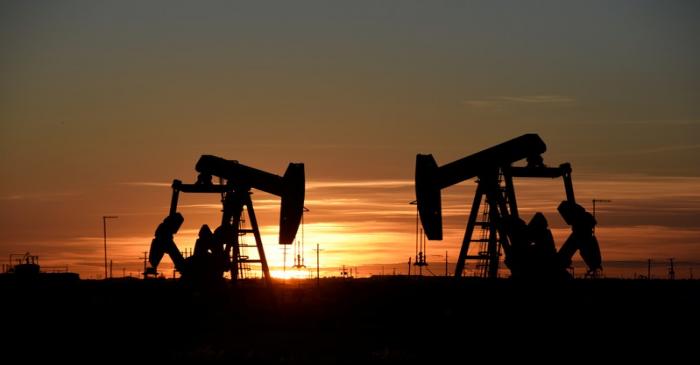 Pump jacks operate at sunset in an oilfield in Texas