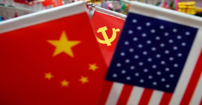 The flags of China, U.S. and the Chinese Communist Party are displayed in a flag stall at the