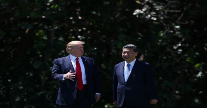 U.S. President Donald Trump and China's President Xi Jinping chat as they walk along the front
