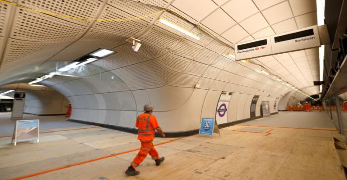 FILE PHOTO: A Crossrail worker walks in the new Farringdon underground station of the Elizabeth